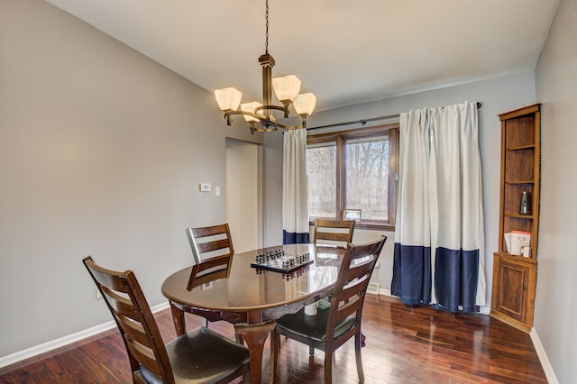 dining space with baseboards, dark wood-type flooring, and an inviting chandelier