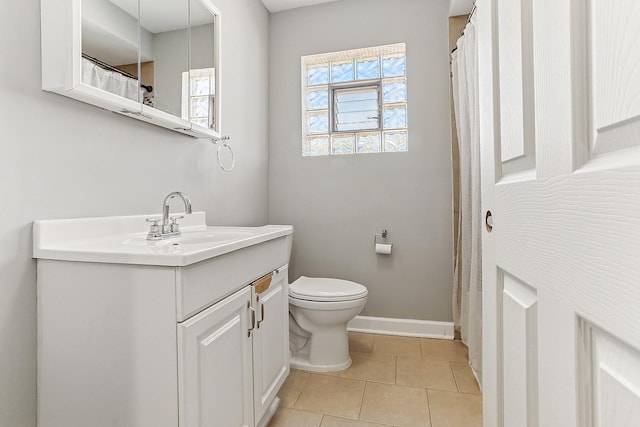 bathroom featuring tile patterned flooring, toilet, vanity, and baseboards