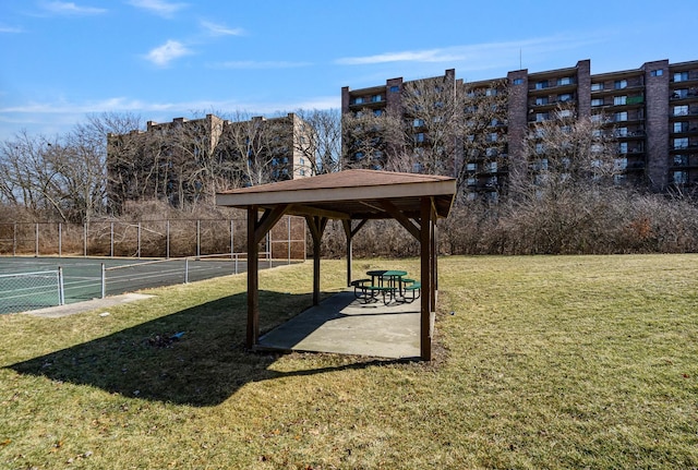 view of property's community featuring a gazebo, a lawn, and fence