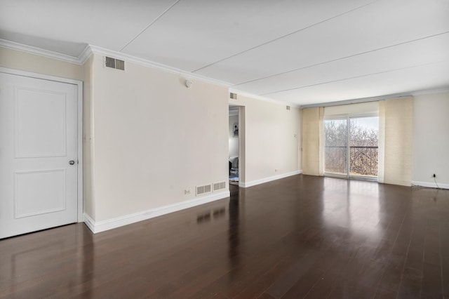 spare room featuring visible vents, ornamental molding, baseboards, and wood finished floors