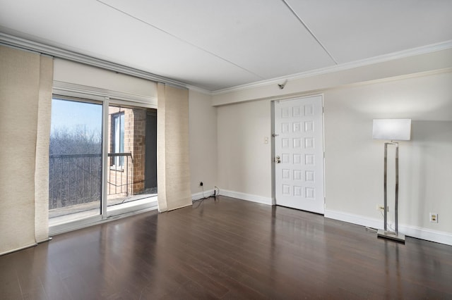 spare room with crown molding, wood finished floors, and baseboards