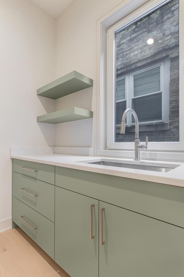 interior details featuring a sink, baseboards, and wood finished floors