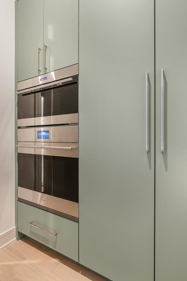 kitchen featuring a sink, open shelves, light stone countertops, and green cabinetry