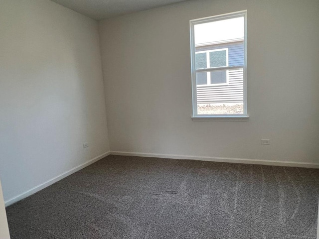 unfurnished room with baseboards and carpet floors