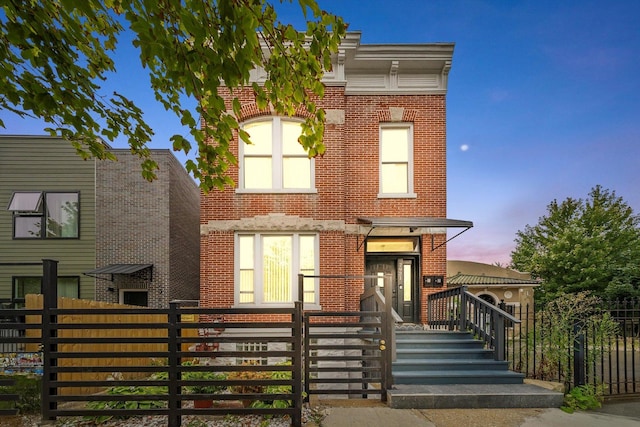 view of front of home featuring brick siding and a fenced front yard