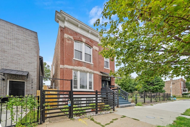 view of front of house with brick siding and a fenced front yard