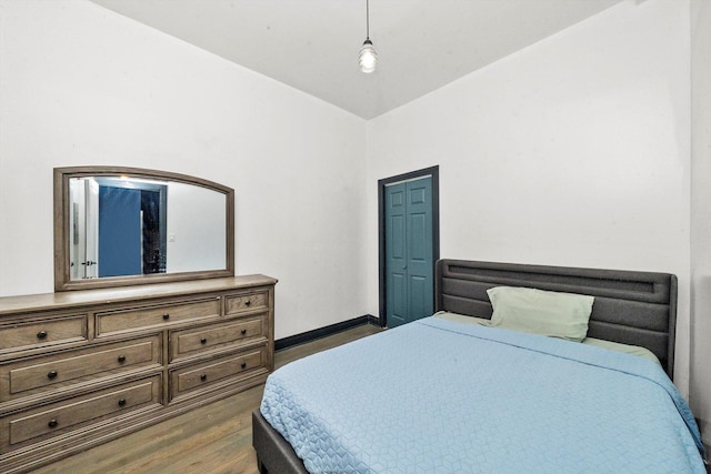 bedroom with baseboards and dark wood-type flooring