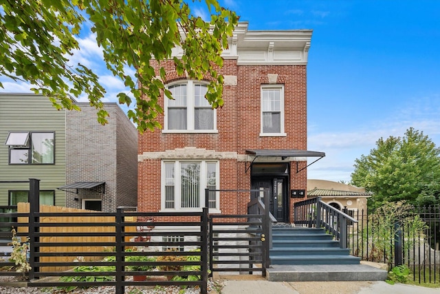 view of front facade with brick siding and a fenced front yard