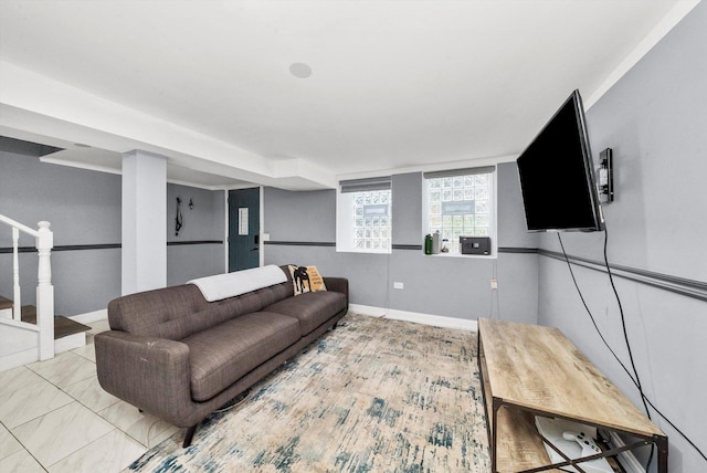 living room featuring stairway and baseboards