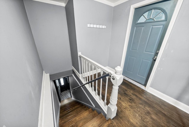 staircase featuring wood finished floors and baseboards