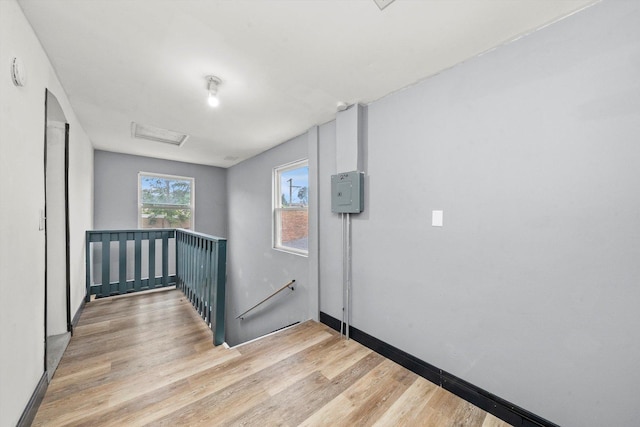 spare room featuring baseboards, attic access, and light wood-style floors