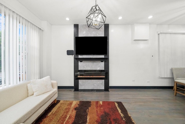 living room featuring wood finished floors, baseboards, and a tile fireplace