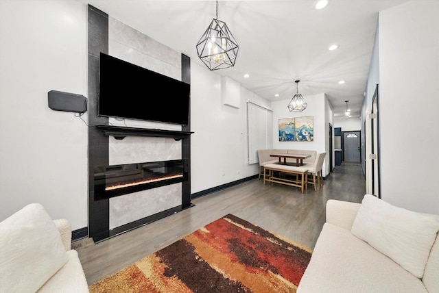 living room with recessed lighting, baseboards, a large fireplace, and wood finished floors