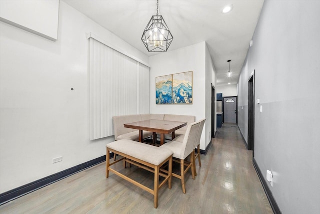 dining room featuring light wood finished floors, recessed lighting, an inviting chandelier, and baseboards