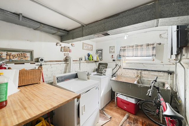 laundry room featuring light wood-style floors, independent washer and dryer, and a sink