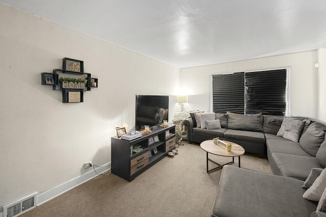 carpeted living area featuring visible vents and baseboards