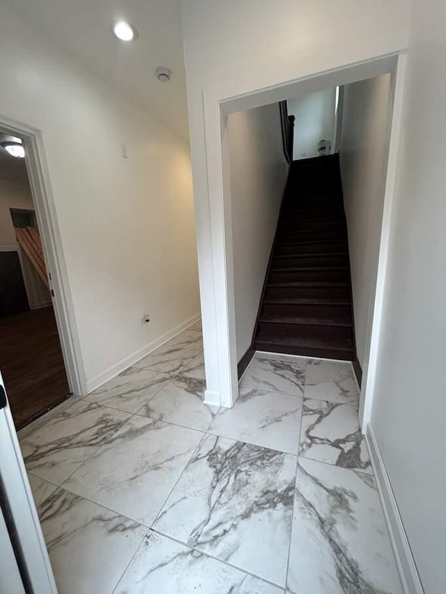 staircase featuring recessed lighting, marble finish floor, and baseboards