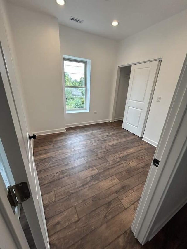 unfurnished bedroom featuring visible vents, recessed lighting, dark wood-type flooring, and baseboards