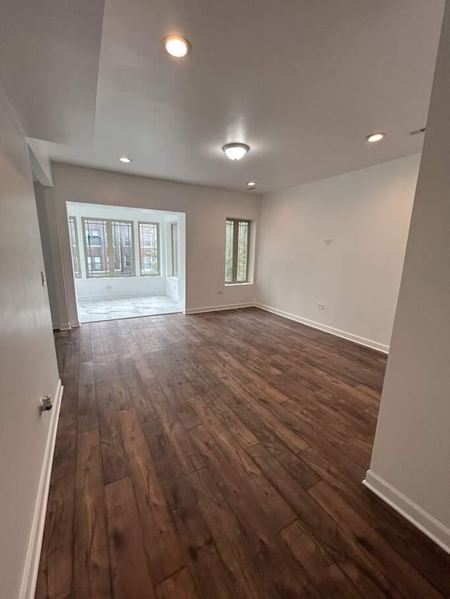 spare room with dark wood finished floors, recessed lighting, and baseboards