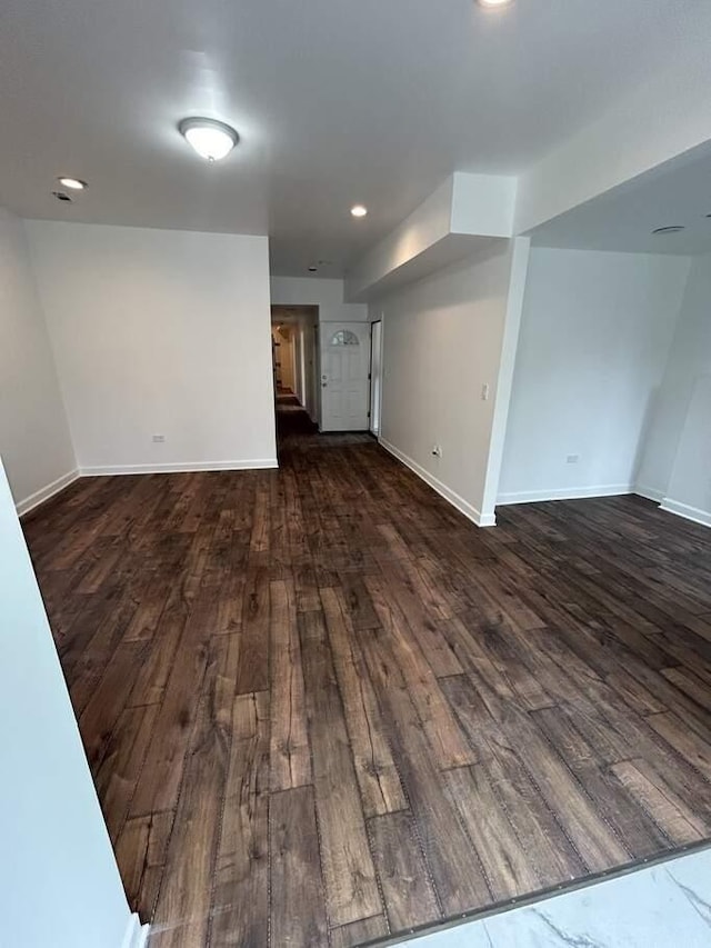 empty room with recessed lighting, stairs, dark wood-type flooring, and baseboards