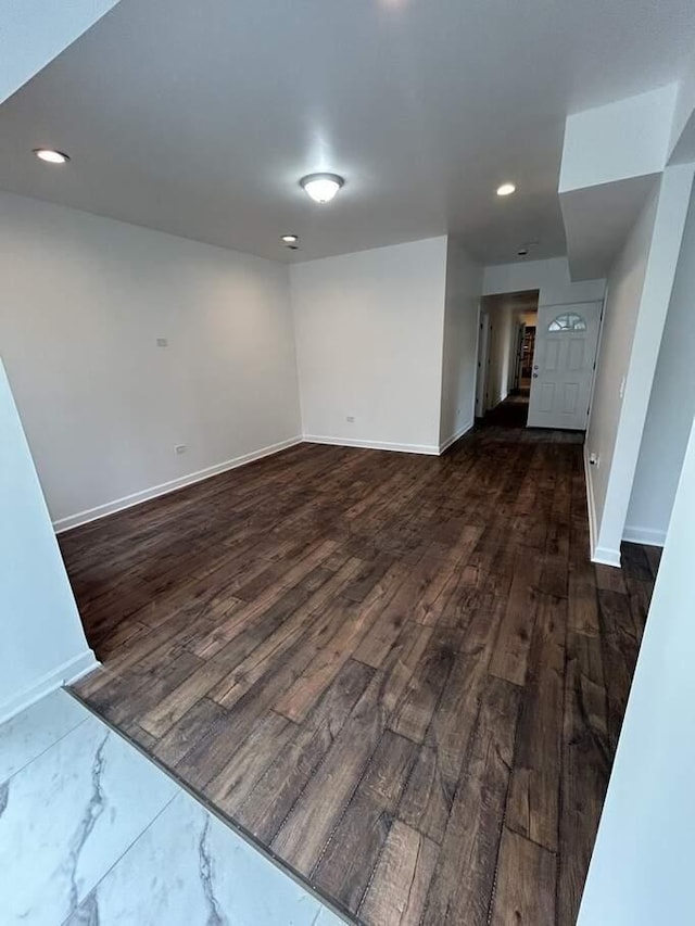 spare room with recessed lighting, baseboards, and dark wood-style flooring