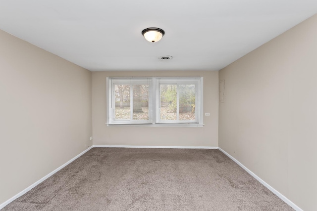 carpeted empty room featuring baseboards and visible vents