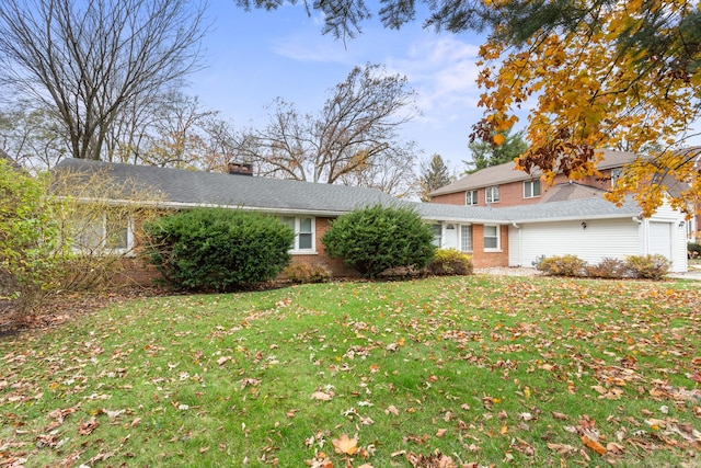 view of front of house featuring brick siding, a garage, a chimney, and a front lawn