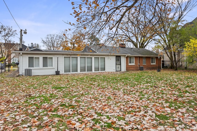 back of house with cooling unit, fence, brick siding, and a chimney