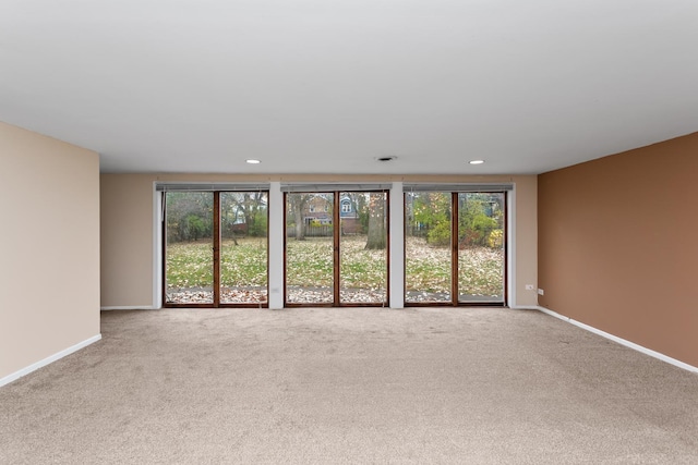 carpeted spare room featuring recessed lighting and baseboards