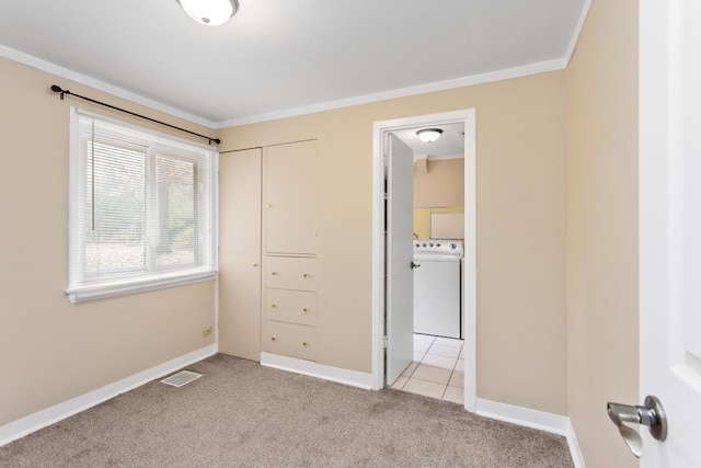 unfurnished bedroom with visible vents, light carpet, ornamental molding, baseboards, and washer / dryer