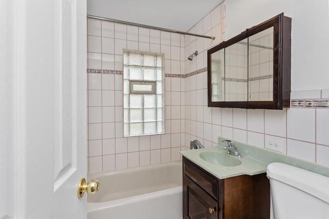 full bathroom with toilet, vanity, decorative backsplash, shower / bathtub combination, and tile walls