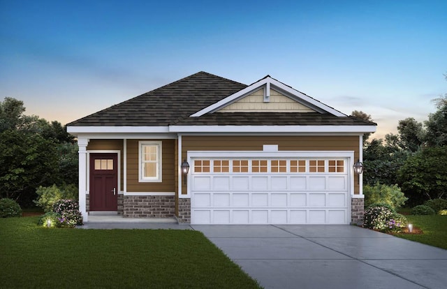 view of front of house with an attached garage, a shingled roof, a lawn, stone siding, and driveway