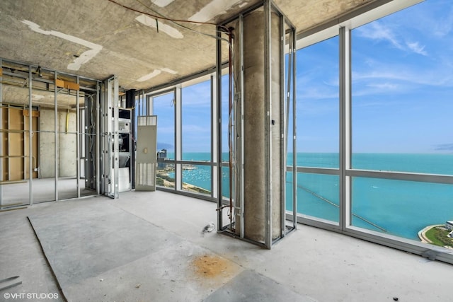 interior space with a water view, concrete flooring, and expansive windows