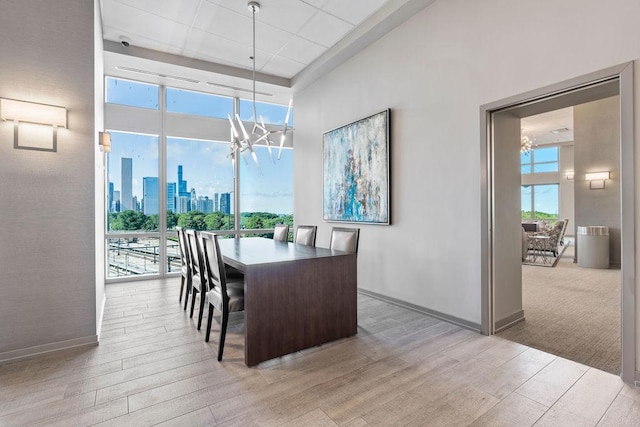 dining space featuring a view of city, a notable chandelier, light wood-style floors, and plenty of natural light