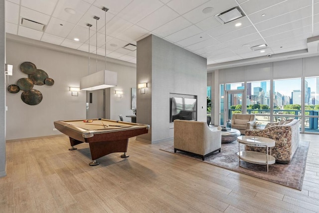 game room featuring visible vents, a view of city, wood finished floors, and a towering ceiling