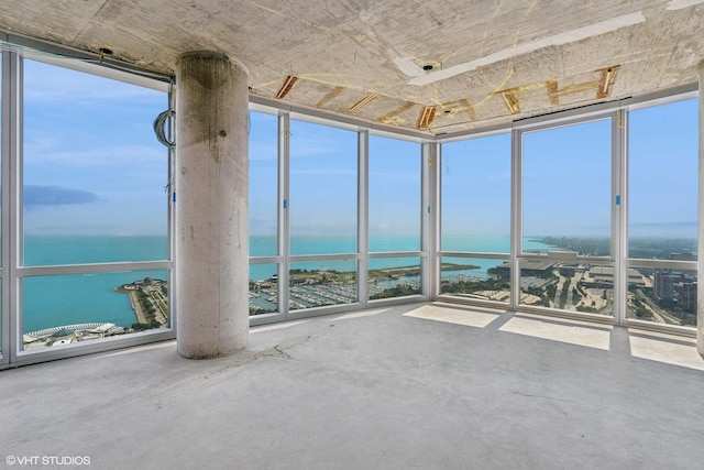 unfurnished sunroom featuring a water view