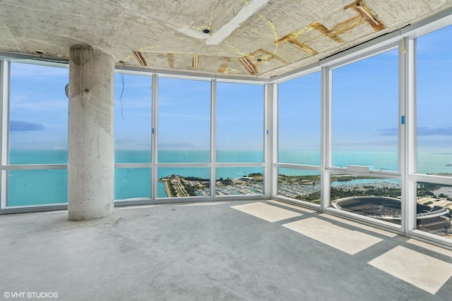 unfurnished sunroom featuring a water view