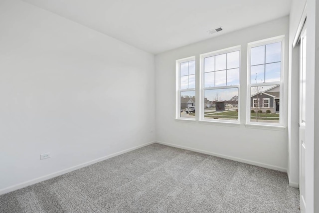 spare room featuring visible vents, baseboards, and carpet