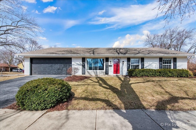 single story home featuring a garage, brick siding, a front yard, and aphalt driveway