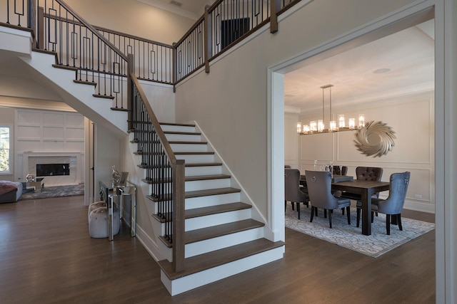 511 N Branch Rd, Glenview, IL 60025 - staircase featuring an inviting chandelier, ornamental molding, wood finished floors, and a fireplace