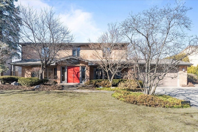 view of front of home featuring driveway, brick siding, an attached garage, and a front yard