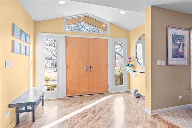 foyer entrance with recessed lighting, baseboards, wood finished floors, and vaulted ceiling