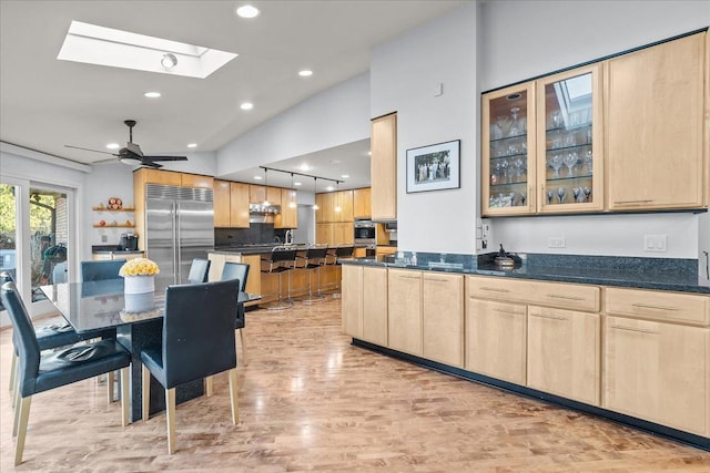 kitchen with stainless steel appliances, glass insert cabinets, and light brown cabinets