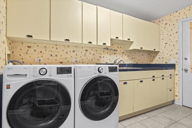 washroom featuring a sink, washing machine and dryer, cabinet space, wallpapered walls, and light tile patterned floors