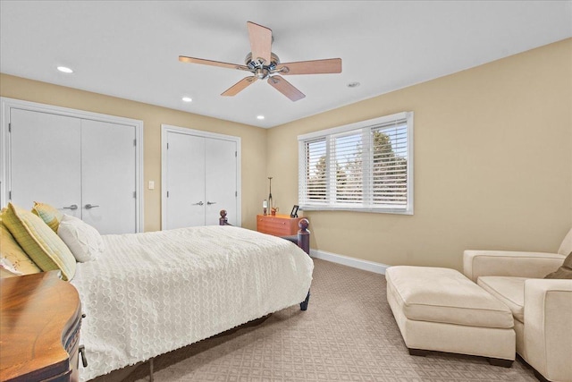 carpeted bedroom featuring recessed lighting, baseboards, multiple closets, and a ceiling fan