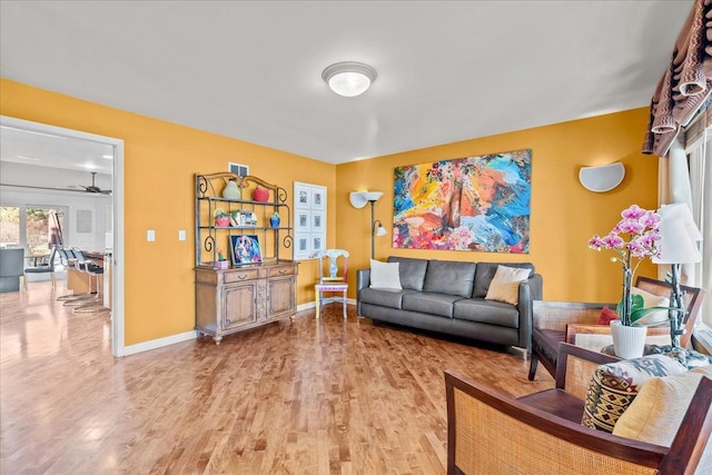 living area featuring visible vents, baseboards, and wood finished floors