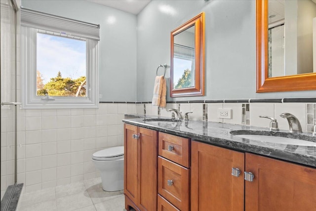 full bathroom with a sink, toilet, tile walls, and tile patterned flooring