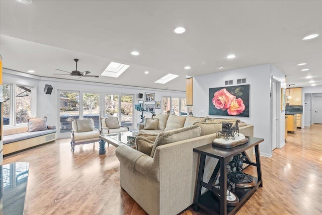 living area with a skylight, recessed lighting, a healthy amount of sunlight, and light wood-style flooring