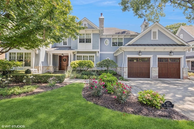 view of front of home featuring driveway, a standing seam roof, stone siding, an attached garage, and metal roof