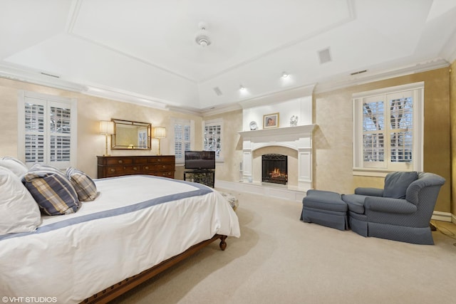 carpeted bedroom with a tray ceiling, a fireplace, and ornamental molding